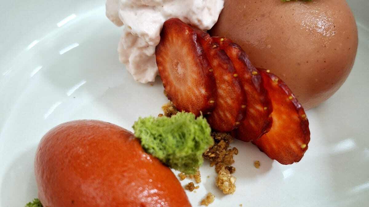 piatto con cheesecake fragole, basilico  e grano saraceno